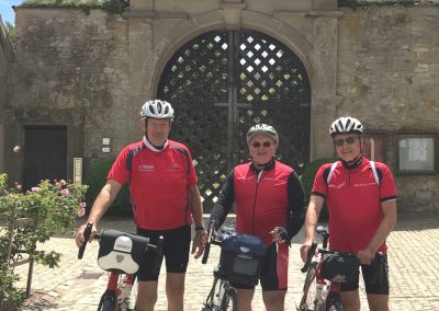 Drei Radfahrer vor einem historischen Gebäude
